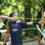 Kids learning archery at summer camps