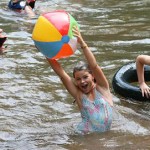 Camper girl playing in the lake at summer camp