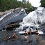 girl summer camp swimming at waterfall