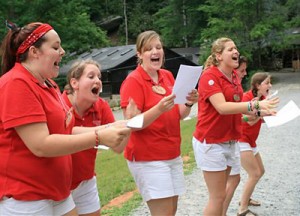 Counselors leading songs at camp assembly