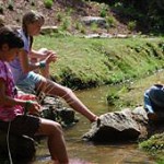 Girls weaving baskets by the creek