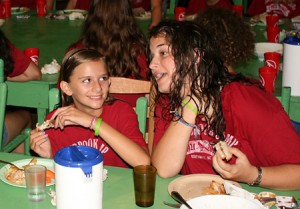 summer camper and counselor at dinner